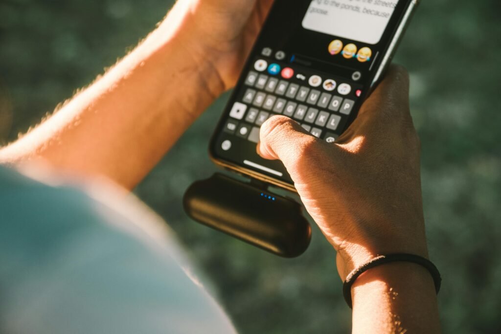 A person charging their smartphone with a compact portable ki power bank, illustrating the convenience and freedom of having on-the-go power for devices.
