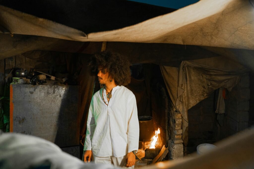 A portable camping woodstove glows warmly inside a canvas tent, providing heat and a cozy atmosphere for cold-weather camping.