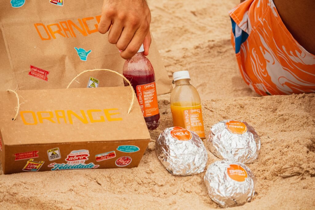 A smiling camper sits on a log in the forest enjoying an easy camping lunch wrap, showcasing a simple and delicious meal idea for outdoor adventures.