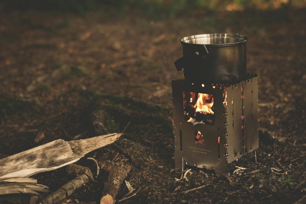 Efficient camping wood cooker in use at a campsite, showcasing sustainable outdoor cooking and a warm, inviting atmosphere.