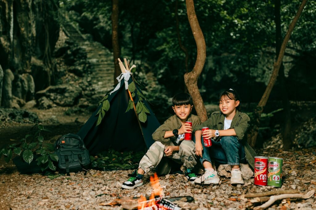 Happy campers enjoying a variety of gourmet smoked snacks like cheese, nuts, and sausage bites, prepared using a portable smoker over a warm campfire in a beautiful natural setting.