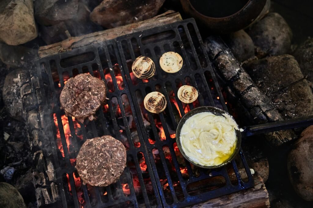 A delicious and easy camping meal being cooked in a cast iron skillet over a glowing campfire, a perfect example of simple campfire dinner ideas.