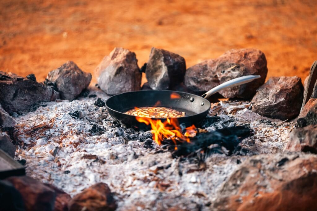 Delicious and energizing camping breakfast cooked on a cast-iron skillet over a campfire, perfect for outdoor adventures.