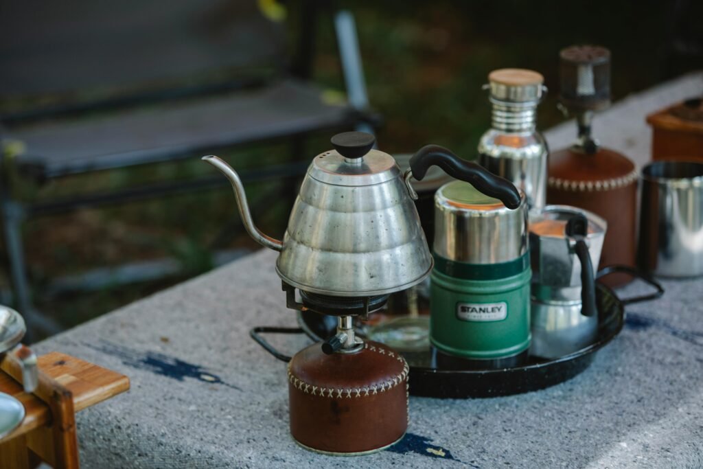 Portable butane cooktop in use for outdoor cooking, ideal for camping, picnics, and emergency situations, showcasing its compact design and efficient flame.