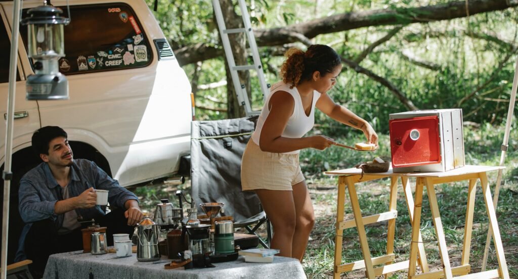 Modern electric camping stove set up for outdoor cooking at a serene campsite, highlighting the convenience and safety of portable electric cooking in nature.