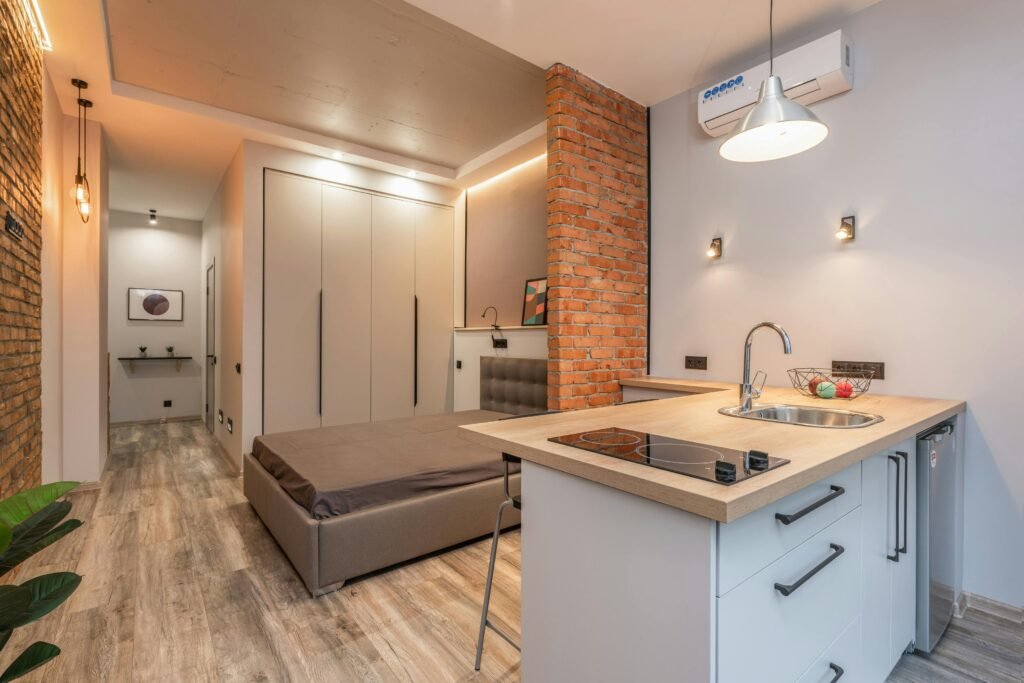 A white and silver portable air fryer sits on a clean countertop in a small, modern kitchen, showcasing a convenient cooking solution for small spaces.