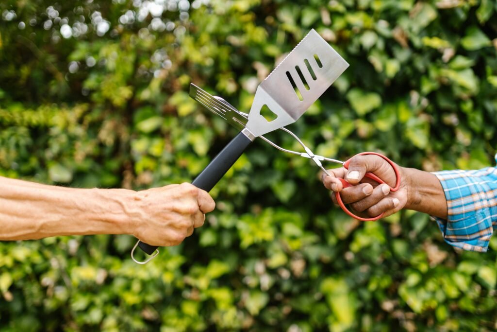 A person's hands carefully installing a genuine Camp Chef part into an outdoor grill to perform a repair.